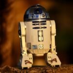 Close-up of a futuristic robot toy outdoors, showcasing its metallic and plastic components.