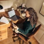 Woman working at a desk with laptop and tablet.