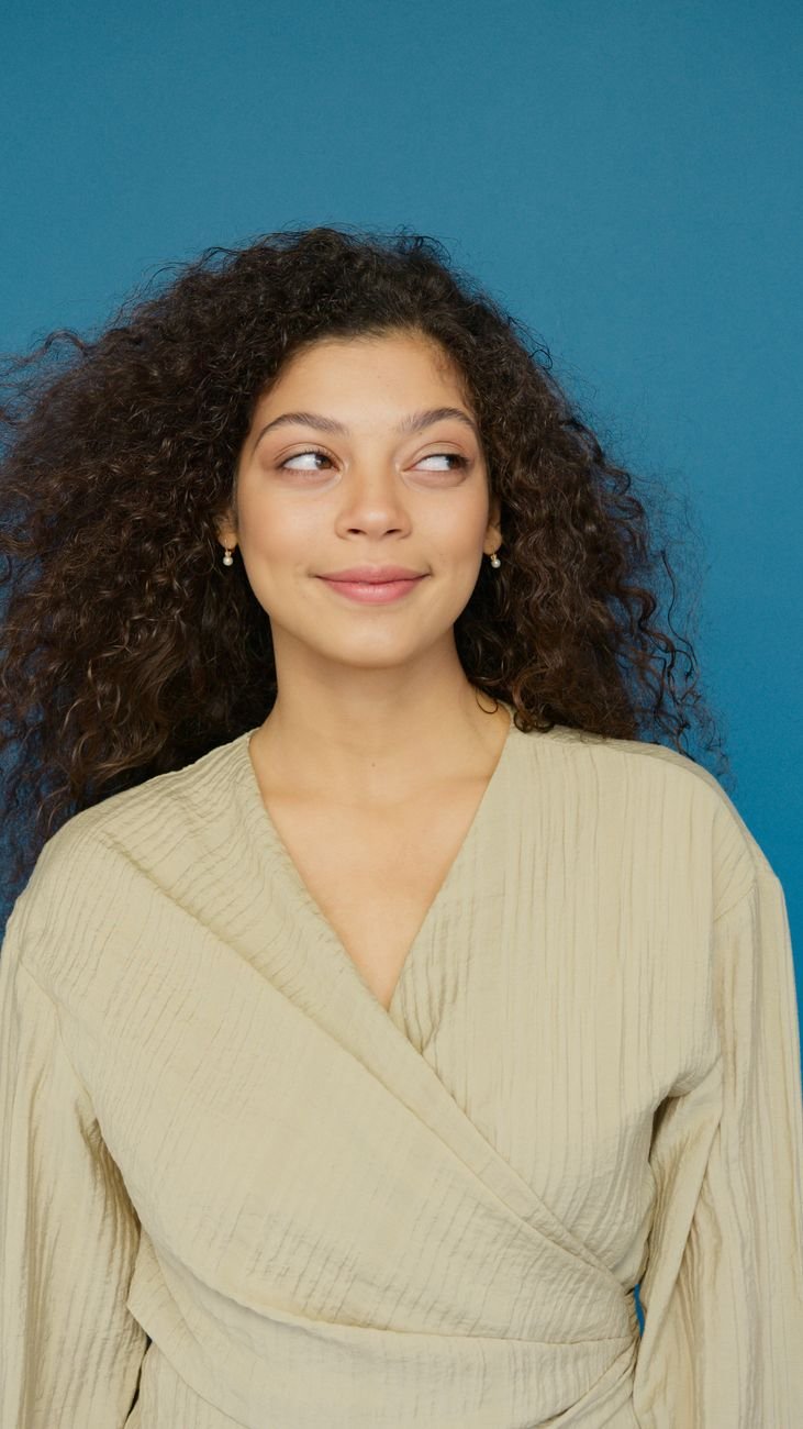 a woman in brown blazer smiling